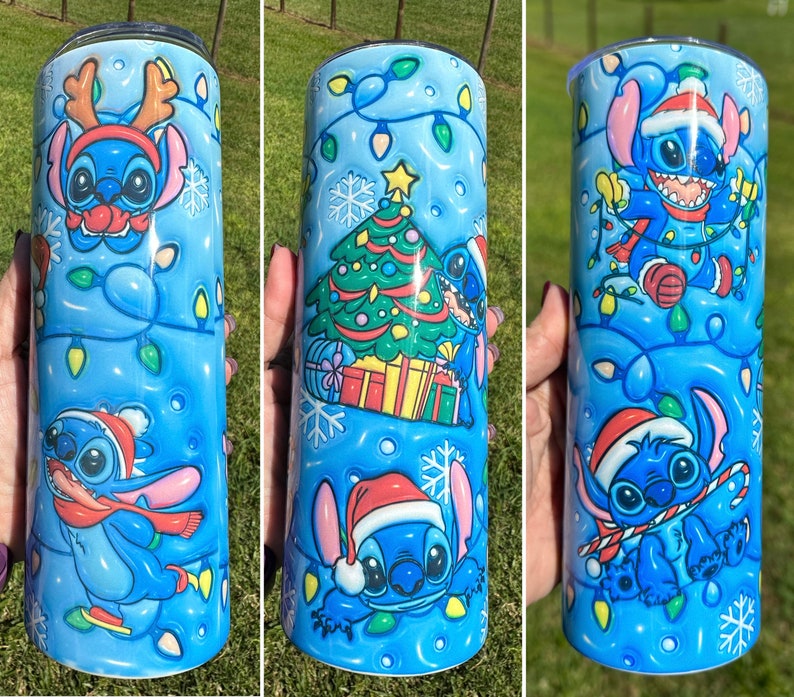 Może przedstawiać: Niebieski i biały kubek z motywem świątecznym z Stitch'em z Lilo & Stitch. Kubek ma niebieskie tło z białymi płatkami śniegu i świątecznymi światełkami. Stitch ma na sobie czapkę Mikołaja i trzyma laskę cukrową.