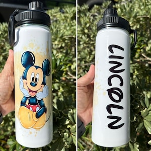 May include: Two white stainless steel water bottles with black lids and handles. One bottle features a cartoon image of Mickey Mouse. The other bottle has the name "Lincoln" written on it in black.