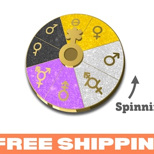 May include: A gold-coloured spinning wheel with six sections, each with a different gender symbol. The sections are black, white, yellow, and purple. The wheel is spinning with an arrow pointing to the right.