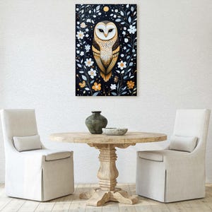 May include: A white owl with yellow eyes and brown markings sits in a frame of white flowers and green leaves on a black background.