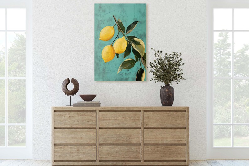 May include: A painting of a lemon tree branch with yellow lemons against a teal background. The painting is framed and hanging on a white wall above a wooden dresser.