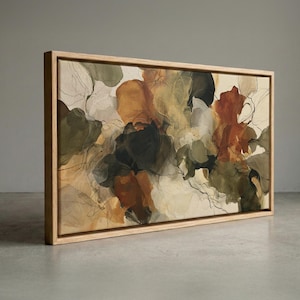 May include: A rectangular canvas painting featuring abstract organic shapes in shades of olive green, burnt orange, cream, and charcoal gray. The artwork is enclosed in a light-toned wooden floating frame, showcasing fluid, layered forms and thin, dark, ink-like lines.