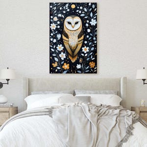May include: A painting of a barn owl with golden brown feathers, perched in a dark forest with white flowers and gold accents. The owl has large, bright yellow eyes and a white face.