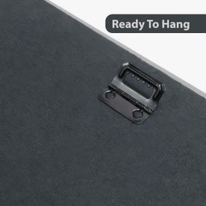 May include: A black metal hanging hardware attached to the back of a canvas print. The hardware is ready to hang on a wall.