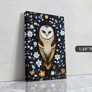 May include: A canvas print featuring a stylised illustration of a barn owl with yellow and white feathers, surrounded by white flowers and black vines on a black background. The text "1.25" Thick" is visible in the lower right corner of the image.