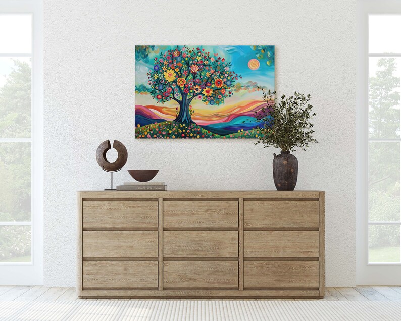 May include: A colorful painting of a tree with flowers and a sunset in the background. The painting is framed and hanging on a white wall above a wooden dresser.