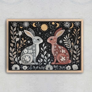 May include: A framed illustration of two rabbits in a forest setting. The rabbits are facing each other and are surrounded by flowers, leaves, and stars. The background is a dark blue color.