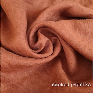 K&ouml;nnte beinhalten: Nahaufnahme eines weichen, strukturierten Stoffes in einem satten, erdigen Braunton. Der Stoff ist zerknittert und gefaltet, was einen nat&uuml;rlichen, organischen Look erzeugt. Der Text "smoked paprika" ist am unteren Rand des Bildes sichtbar.