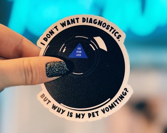 May include: A black and white sticker with a magic eight ball design. The sticker says "I don't want diagnostics. But why is my pet vomiting?" and has a blue triangle with the text "Ask again later" inside.