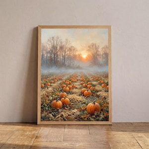 May include: A framed wall art print depicting a pumpkin patch at sunrise. The scene features numerous orange pumpkins resting on dry straw and earth, with a misty forest background under a soft, glowing sky with trees in the distance.