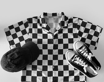 May include: Black and white checkered short-sleeve shirt, a black baseball cap, and black canvas sneakers with white laces. The shirt and sneakers are arranged on a light background. The shirt has a button-down front.