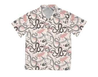 Peut inclure: Chemise à manches courtes avec un fond crème et un motif répété de serpents gris et noirs, ainsi que des formes de feuilles roses et grises. La chemise a un col classique et une coupe décontractée.