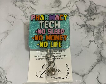 May include: A teal glitter badge reel with the text "PHARMACY TECH -NO SLEEP -NO MONEY -NO LIFE" in various colors. The reel has a clear plastic ID holder and a metal clip.