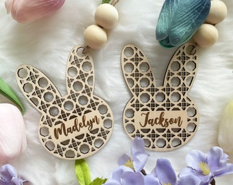 Op de afbeelding: Twee houten konijnen-versieringen met ingewikkelde lasergesneden ontwerpen. De versieringen zijn gepersonaliseerd met de namen "Madelyn" en "Jackson".
