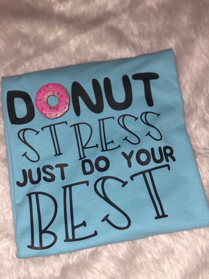May include: Light blue t-shirt with a donut graphic and the text "Donut stress just do your best".