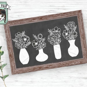May include: Four white line drawings of flower bouquets in vases on a black chalkboard background. The chalkboard is framed in brown wood.
