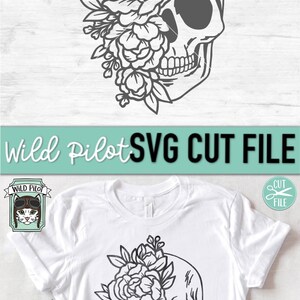 May include: A black and white line art design of a skull with flowers covering one eye. The skull is facing right and has a detailed design. The flowers are stylized and have a simple design. The design is on a white t-shirt.