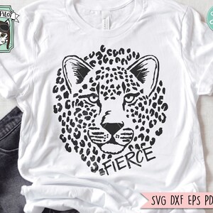 May include: Black and white graphic design of a leopard's face with the word "FIERCE" underneath. The design is on a white t-shirt.