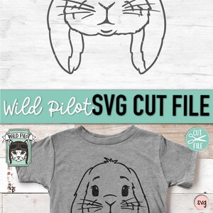 May include: A black and white line drawing of a bunny rabbit's face with large ears. The image is on a gray t-shirt with a white background. The text "Wild Pilot" is in a white rectangle with a black border. The text "SVG CUT FILE" is in black text on a teal background. The text "CUT FILE" is in white text on a pink circle with a pair of scissors.