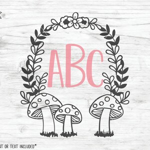 Op de afbeelding: Een zwart-witte bloemenkrans met een roze "ABC" in het midden. Drie zwart-witte paddenstoelen bevinden zich onderaan de krans.