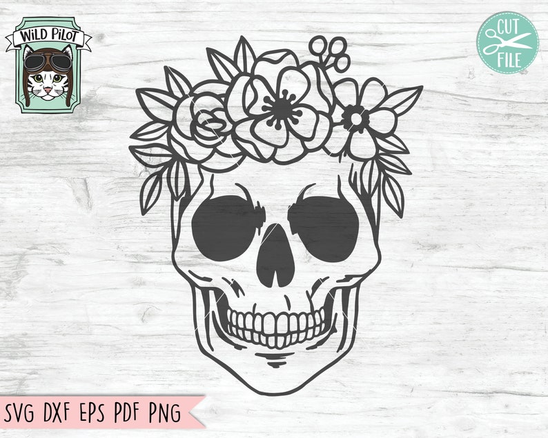 Pu&ograve; includere: Illustrazione in bianco e nero di un teschio con una corona di fiori. Il teschio ha un grande sorriso ed &egrave; circondato da fiori.