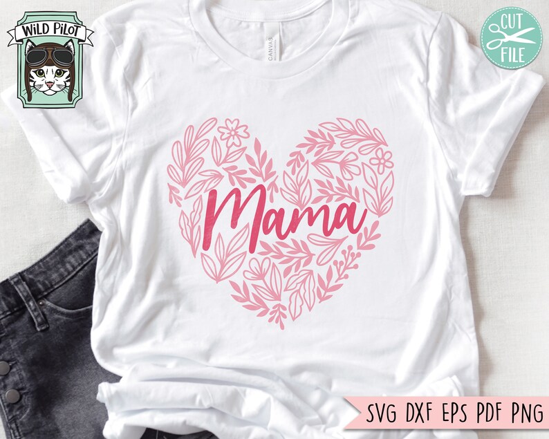 Pu&ograve; includere: Maglietta bianca con un design a forma di cuore rosa con la parola "Mama" circondata da elementi floreali.