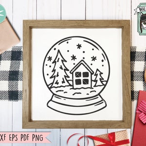 Op de afbeelding: Zwart-witte lijntekening van een sneeuwbol met een klein huis, twee dennenbomen en sneeuwvlokken erin. De sneeuwbol staat op een houten oppervlak.