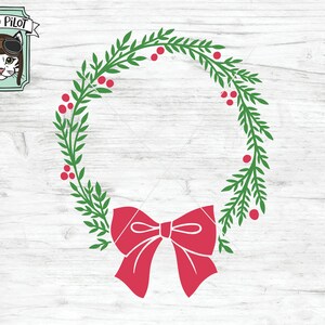 May include: A green wreath with red berries and a large red bow. The wreath is on a white wood background.