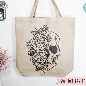 May include: A tote bag with a black and white design of a skull with flowers growing out of the eye socket. The text "SVG DXF EPS PDF PNG" is at the bottom of the bag.