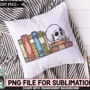 May include: A white pillow with a stack of colorful books and a white skull on top. The books have a vintage look and are stacked on top of each other. The skull is facing to the right and has a detailed design. The pillow is on a striped fabric background.