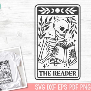 May include: A black and white illustration of a skeleton reading a book, labelled "The Reader." The design includes a crescent moon, stars, and leafy branches. A white t-shirt with the same design is also shown.