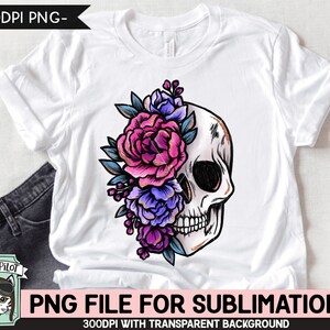 Puede incluir: Una camiseta blanca con un dise&ntilde;o de sublimaci&oacute;n de una calavera con flores rosas, moradas y azules.
