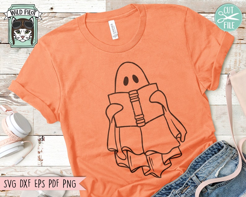 May include: A digital design featuring a ghost reading a book. The ghost is outlined in black and the book is filled in with black. The design is on a peach colored t-shirt.