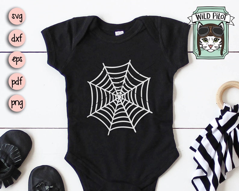 May include: Black baby onesie with a white spiderweb design. The onesie is on a white wooden surface.