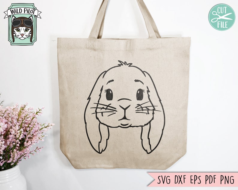 May include: A beige tote bag with a black outline of a bunny rabbit face. The bunny has large ears, big eyes, and a small nose.