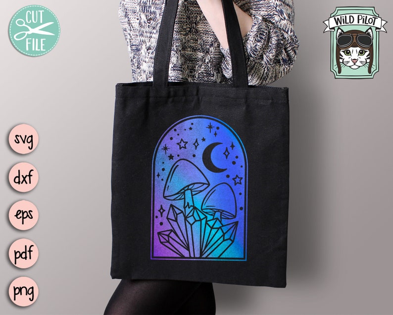 May include: A black tote bag with a design of mushrooms, crystals, and a crescent moon in a blue and purple gradient arch. The design is surrounded by stars.