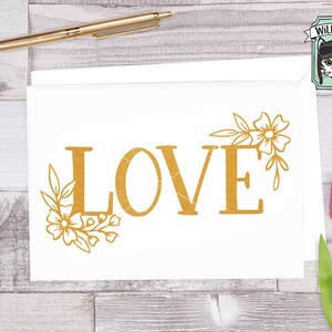 May include: Gold glitter 'LOVE' text with a floral design on a white background.