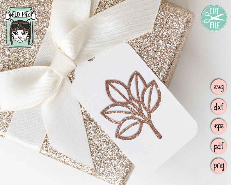 May include: A gold glitter gift box with a white satin ribbon and a white tag with a brown leaf design. The tag also has the text "CUT FILE" in a pink circle with scissors.
