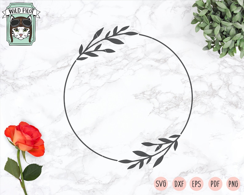 May include: A black and white circular frame with leafy branches on either side. The frame is on a white marble background.