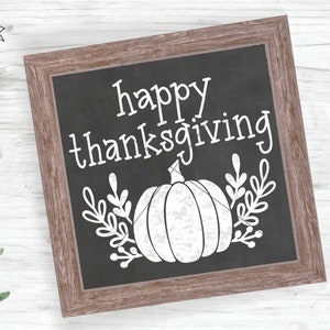 May include: A chalkboard sign with a white wooden frame. The sign says "happy thanksgiving" with a white pumpkin and leaves.