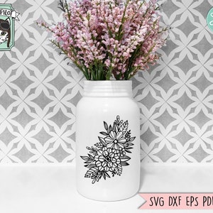 Puede incluir: Un jarr&oacute;n de cer&aacute;mica blanco con un dise&ntilde;o floral negro. El jarr&oacute;n est&aacute; lleno de flores rosas y est&aacute; sobre una superficie de azulejos blancos.