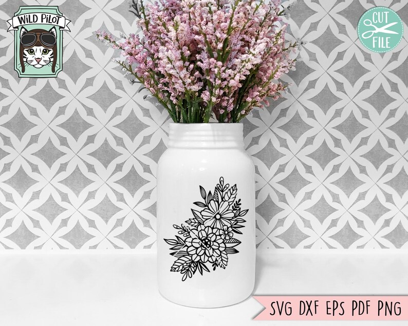 Puede incluir: Un jarr&oacute;n de cer&aacute;mica blanco con un dise&ntilde;o floral negro. El jarr&oacute;n est&aacute; lleno de flores rosas y est&aacute; sobre una superficie de azulejos blancos.