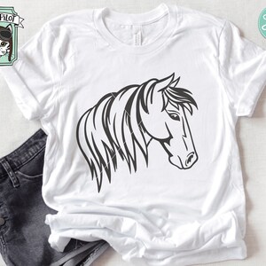 May include: A black and white line art illustration of a horse's head with a mane. The horse is facing to the right. The image is on a white t-shirt.