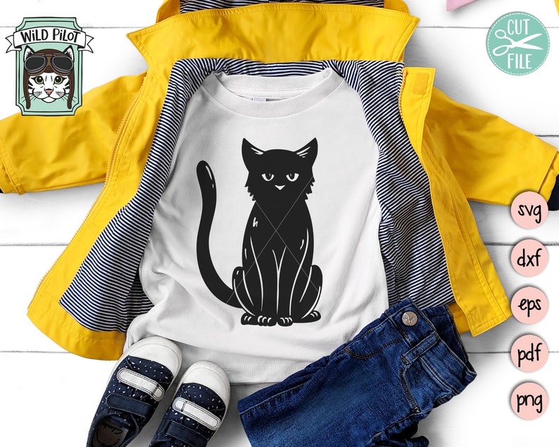 May include: A white t-shirt with a black silhouette of a cat sitting with its tail curled around its legs. The t-shirt is folded and laid on top of a yellow jacket with black stripes. A pair of blue jeans and a pair of blue sneakers are also in the image.