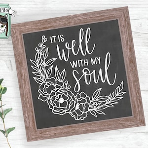 May include: A black chalkboard with a white wooden frame. The chalkboard has a floral design and the text "It is well with my soul".