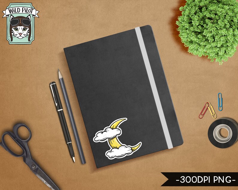 May include: A black notebook with a white elastic band closure. A yellow crescent moon sticker with white clouds is on the front cover. The notebook is on a brown surface with a pair of scissors, two pens, and paper clips.