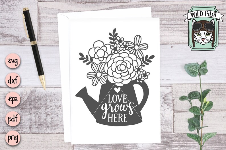May include: A black and white printable design of a watering can with flowers and the text "Love grows here".