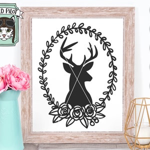 K&ouml;nnte beinhalten: Schwarze Silhouette eines Hirschkopfes mit Geweih in einem Kranz aus Bl&auml;ttern mit Rosen am Boden. Das Design ist auf wei&szlig;em Hintergrund.