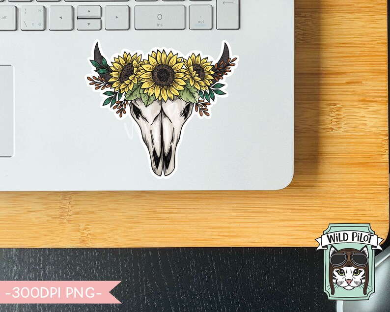 May include: A sticker featuring a white bull skull with a floral crown of yellow sunflowers and green leaves. The sticker is on a laptop.