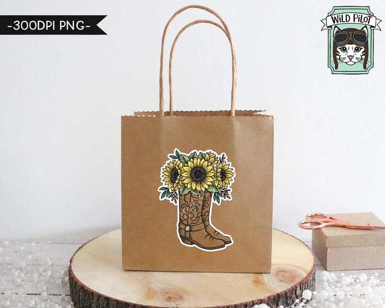 May include: A brown paper gift bag with a sticker of a pair of cowboy boots with sunflowers on top. The sticker says "Wild Pilot" with a cartoon cat wearing aviator sunglasses.